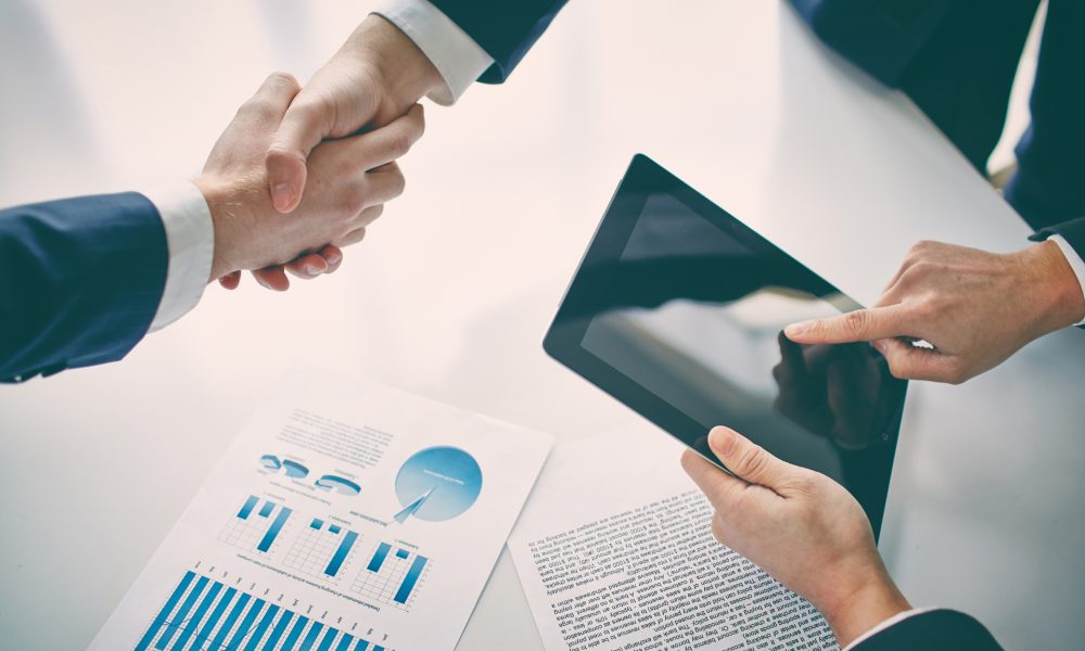 Concluding contract Managers shaking hands over business plans